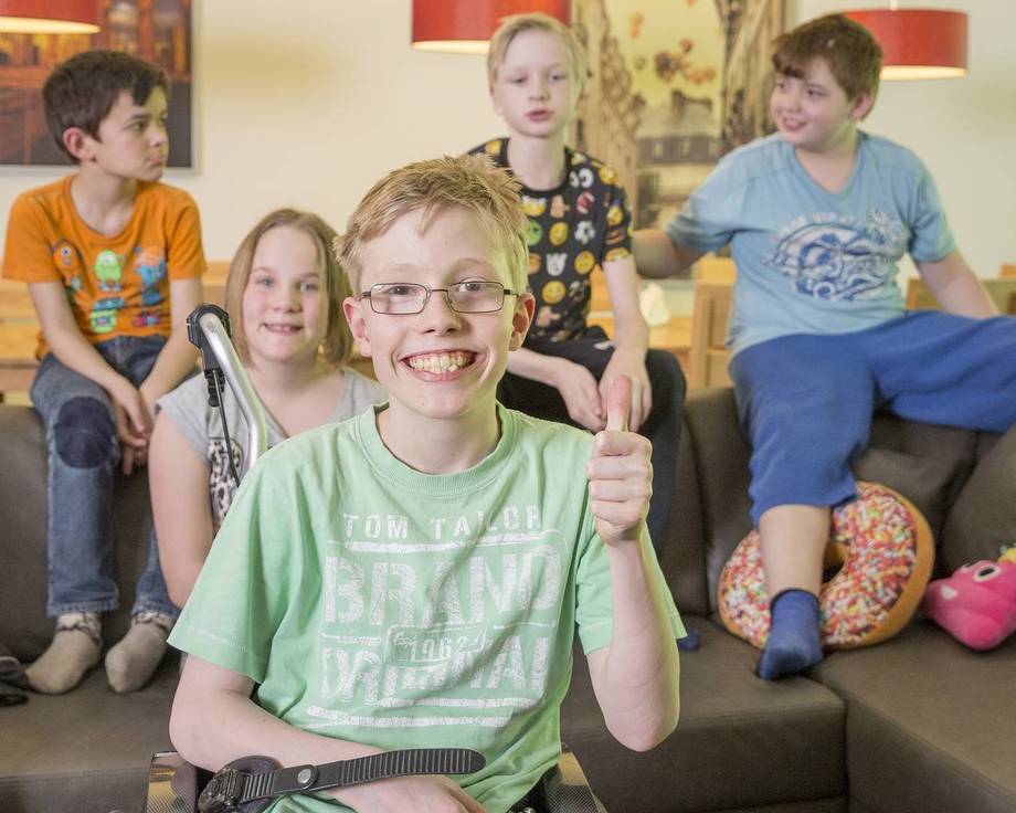 Interntasschüler:innen sitzen auf der Couch und befinden sich gut gelaunt im Wohnzimmer der Internatsgruppe.